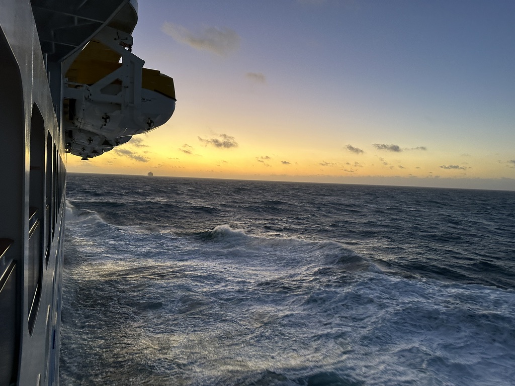 Hohe Wellen neben der AIDAnova bei Sonnenuntergang