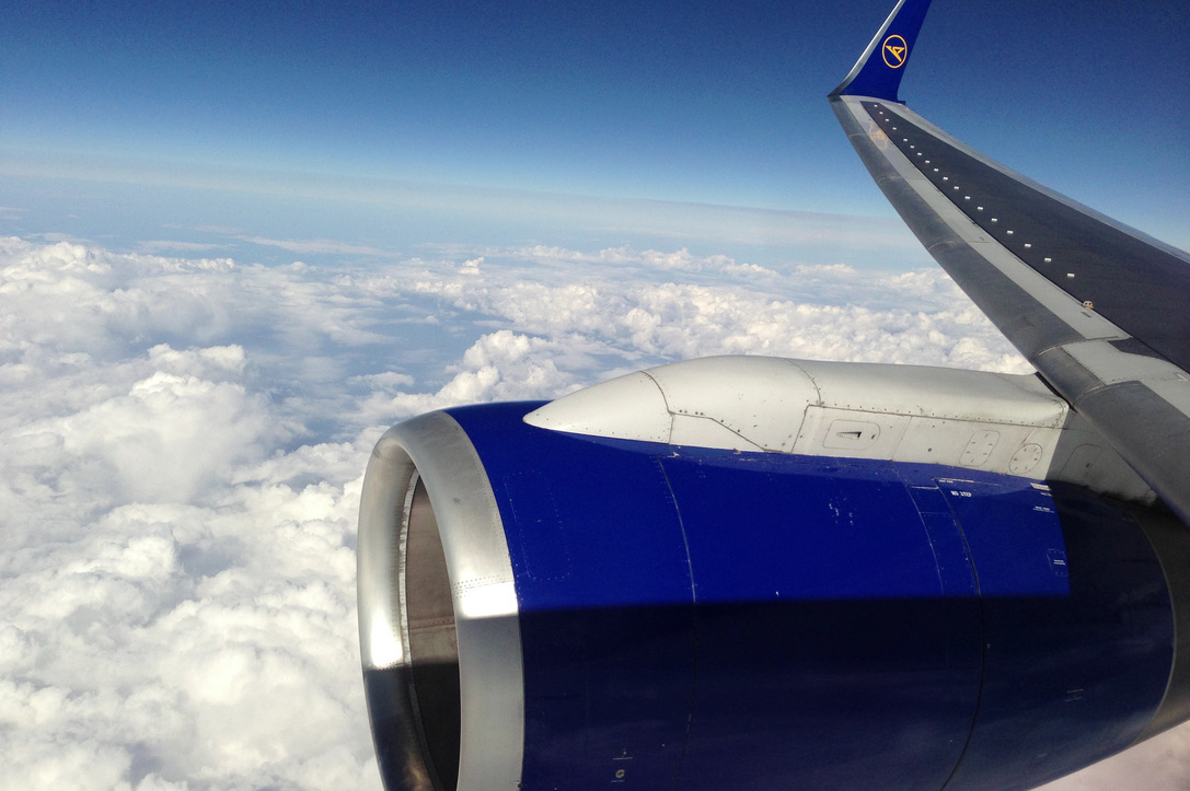 Blick aus einem Flugzeug auf Flügel und Wolken bei Abendlicht