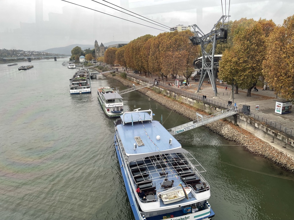 Mehrere Flussschiffe am Koblenzer Rheinufer unter der Seilbahn