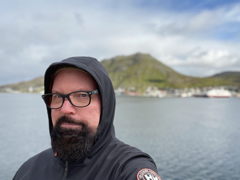 Persönliche Aufnahme an einem nordischen Hafen vor grüner Küstenlandschaft