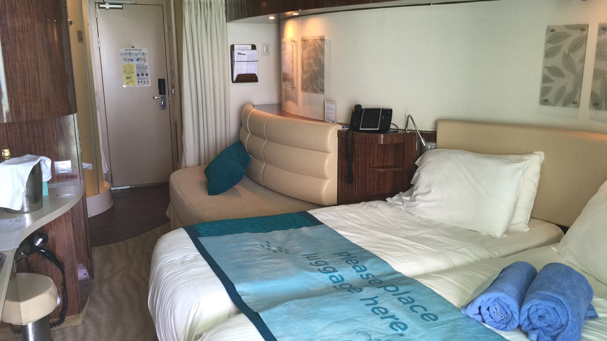 Bett und Sofa in einer Balkonkabine der Norwegian Epic