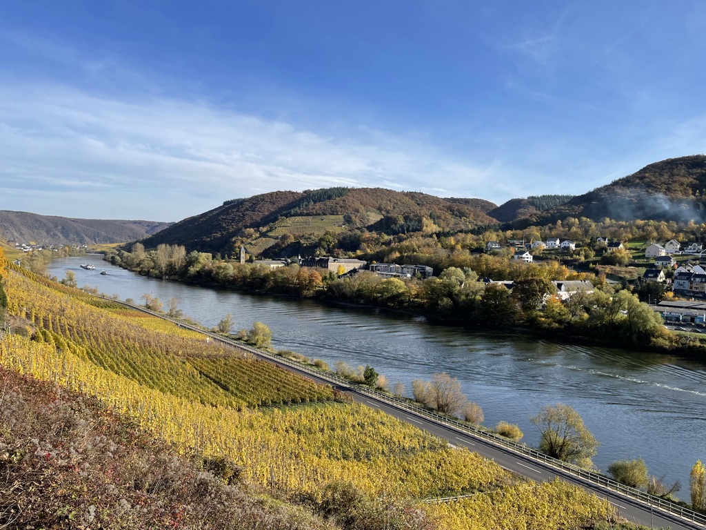 Flusslandschaft mit herbstlichen Weinbergen und kleinen Orten