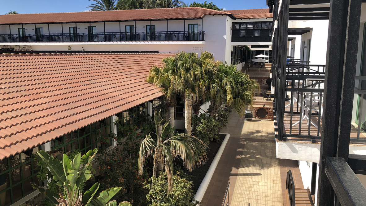 Haupthaus des Aldiana Club Fuerteventura mit Balkonen und begrüntem Innenbereich