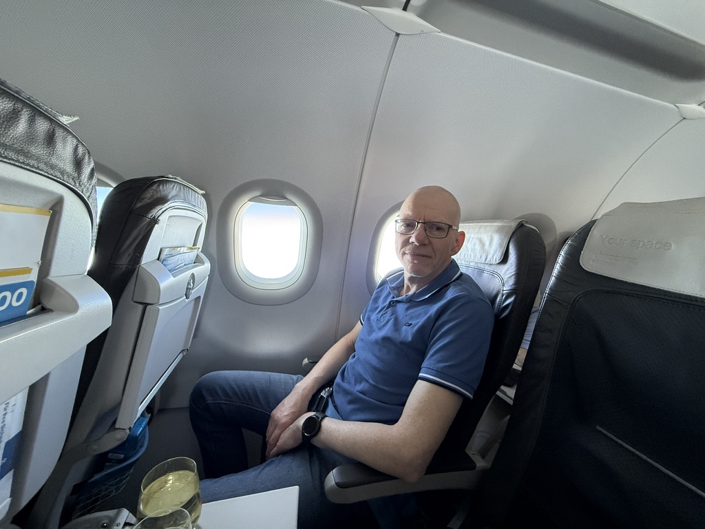 Jürgen auf einem Sitzplatz am Fenster im Flugzeug
