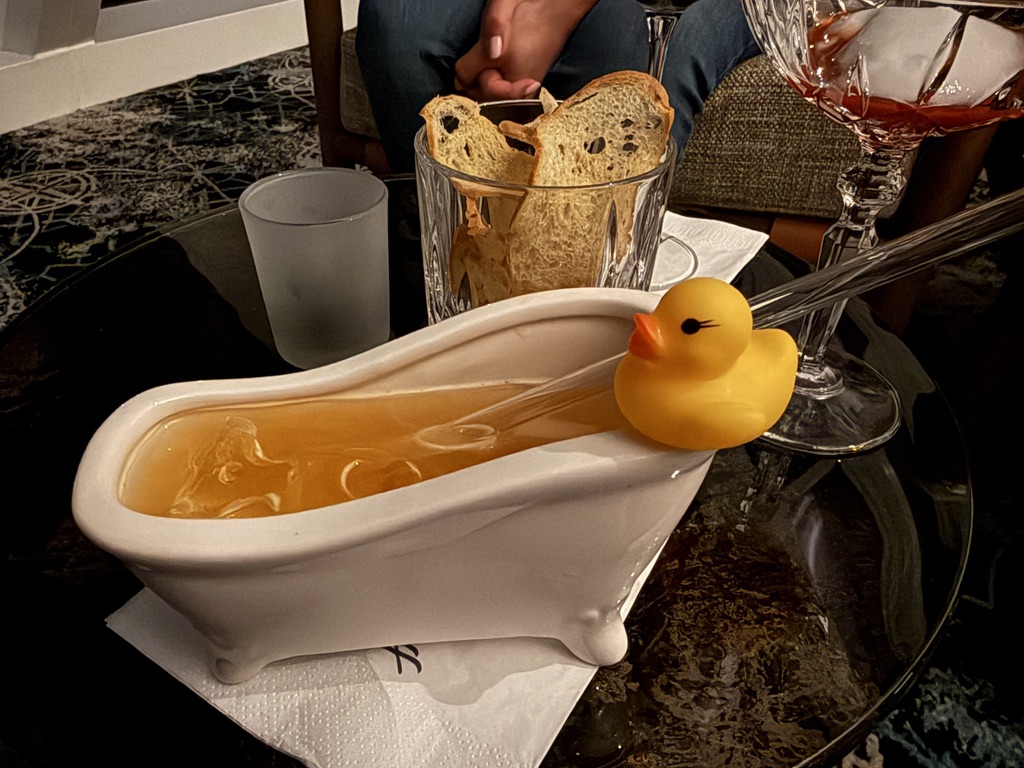 Elisabeth Swan in einer kleinen weißen Badewanne mit gelber Ente