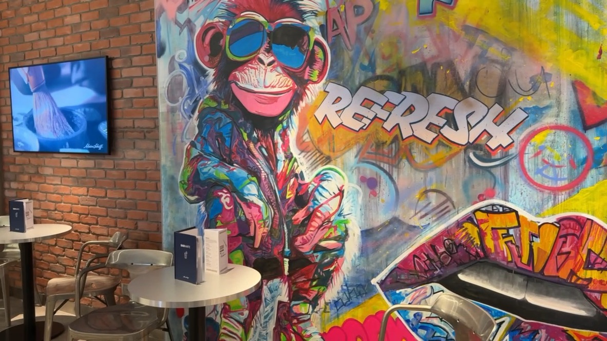 Sitzplätze vor einer bunten Graffitiwand in der Street Art Bar auf der Mein Schiff Relax