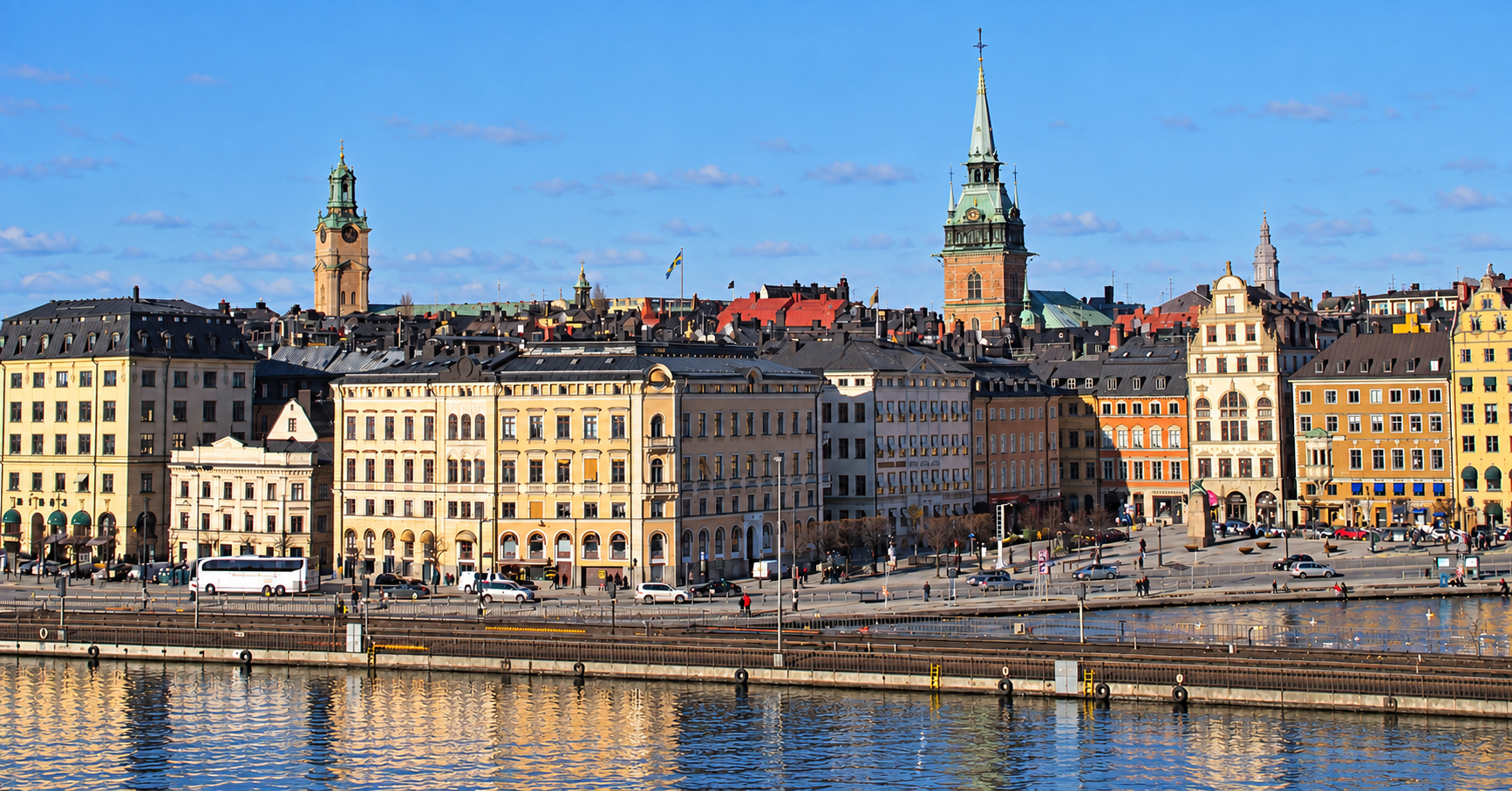 Blick auf die farbige Stockholmer Altstadt mit Kirchtürmen, Kai und Wasser